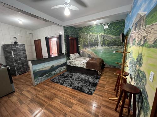 1 dormitorio con 1 cama y una pintura en la pared en Casa Do Guh, en São Thomé das Letras