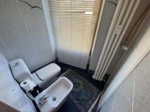 a bathroom with a white toilet and a sink at Grazioso monolocale in Borgata Sestriere