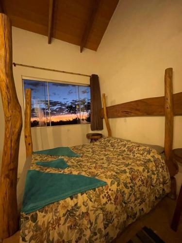 a bedroom with a bed and a window at Chalé jatobá, venha viver essa experiência!!! in Alto Paraíso de Goiás