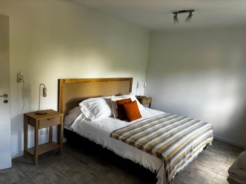 a bedroom with a large bed with orange pillows at Al Río in San Antonio de Areco