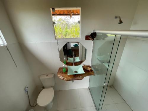 a bathroom with a toilet and a sink and a mirror at Chalé jatobá, venha viver essa experiência!!! in Alto Paraíso de Goiás
