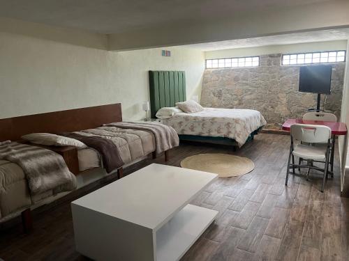 a hotel room with two beds and a couch at La casa del Petirrojo in Tequisquiapan