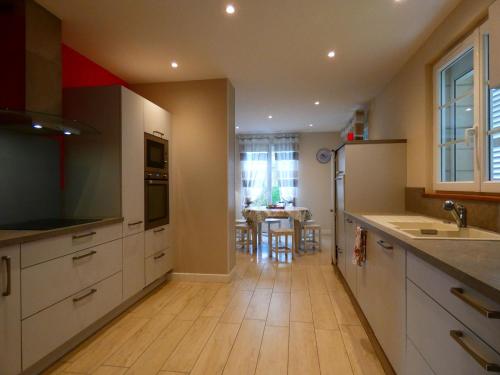 a kitchen with white cabinets and a wooden floor at Maison en pierre rénovée, 3 chambres, jardin clos, équipée, calme et proche étang à Senonches - FR-1-581-36 in Senonches