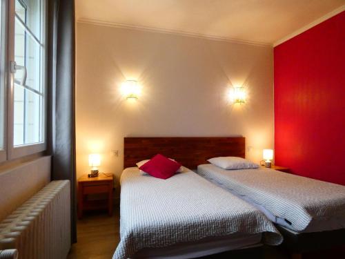 two beds in a room with red and white at Maison en pierre rénovée, 3 chambres, jardin clos, équipée, calme et proche étang à Senonches - FR-1-581-36 in Senonches