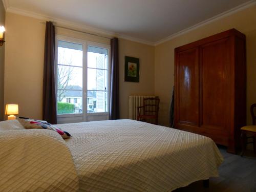 a bedroom with a bed and a large window at Maison en pierre rénovée, 3 chambres, jardin clos, équipée, calme et proche étang à Senonches - FR-1-581-36 in Senonches