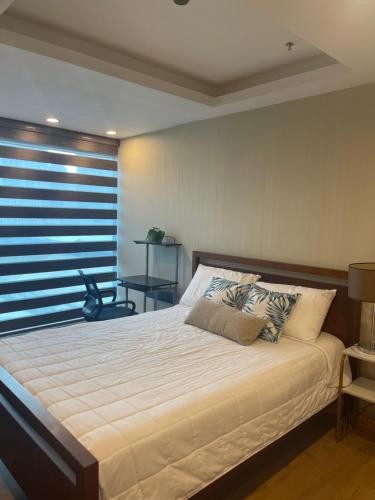 een slaapkamer met een groot bed en een raam bij BSA TWIN TOWER in Manilla