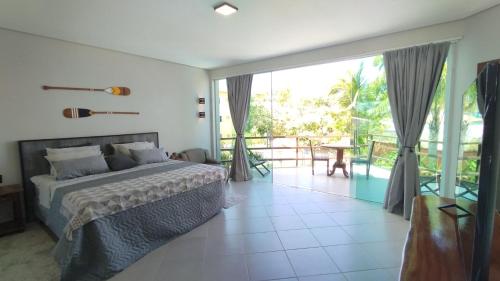 a bedroom with a bed and a sliding glass door at Pousada Novo Prado in Prado
