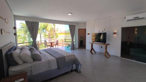 a bedroom with a bed and a television and a balcony at Pousada Novo Prado in Prado