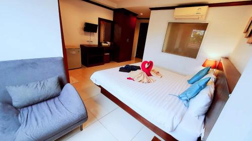 ein Schlafzimmer mit einem Bett, an dem ein rosa Band hängt in der Unterkunft 水果天堂旅馆Fruit Paradise in Patong Beach