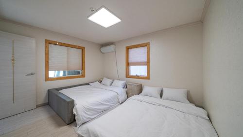 een slaapkamer met 2 bedden en een raam bij Amuse 545 in Yangpyeong