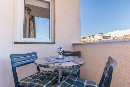 een kleine tafel en stoelen op een balkon bij Apartments with a parking space Porec - 22124 in Poreč