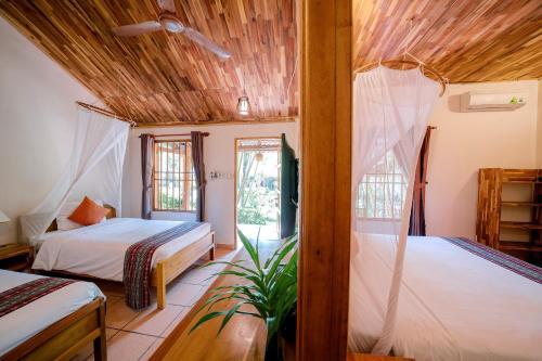 1 Schlafzimmer mit 2 Betten und einem Fenster in der Unterkunft La Mer Resort, Phú Quốc in Phu Quoc