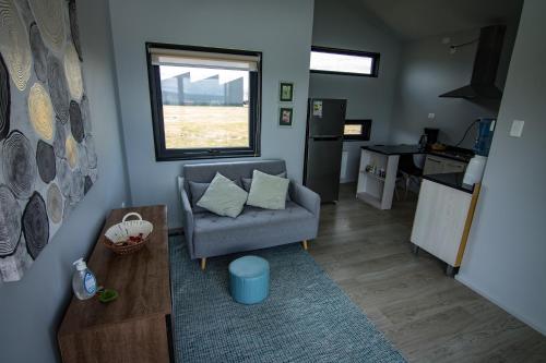 a living room with a couch and a window at Cabaña Julián Elias Verde in Puerto Natales