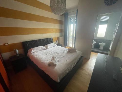 a bedroom with a bed with a striped wall at Onorato vigliani 197 in Turin