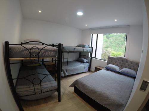 a bedroom with bunk beds and a bed and a window at Finca terraviva in Moniquirá