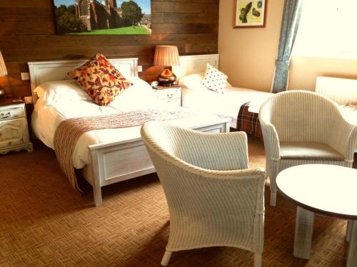 a hotel room with two beds and chairs and a table at The Waterman's Arms in Totnes