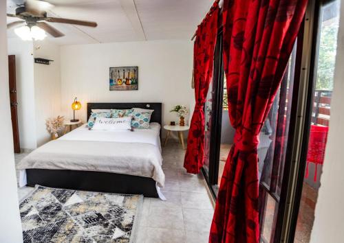 伊瓦格的住宿－Coliving7 Aparta Hotel & Habitaciones，一间卧室配有床和红色窗帘