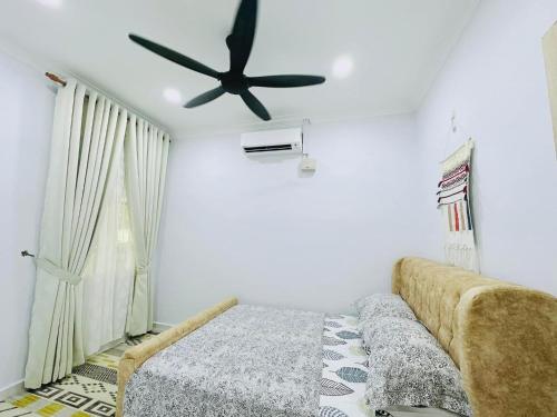 - une chambre avec un lit et un ventilateur de plafond dans l'établissement TeratakAyahBonda, à Kuala Terengganu