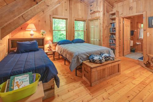 1 dormitorio con 2 camas en una cabaña de madera en River Retreat Cabin en Arden