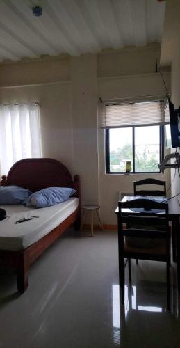 a bedroom with a bed and a chair and a window at CRYSTAL CONDO RENTAL in Calamba