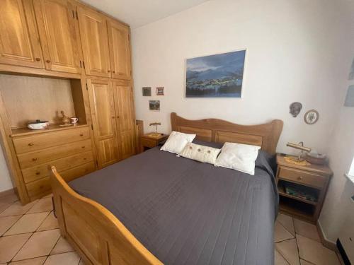 1 dormitorio con 1 cama grande de madera en una habitación en Bilocale elegante a Pragelato en Pragelato