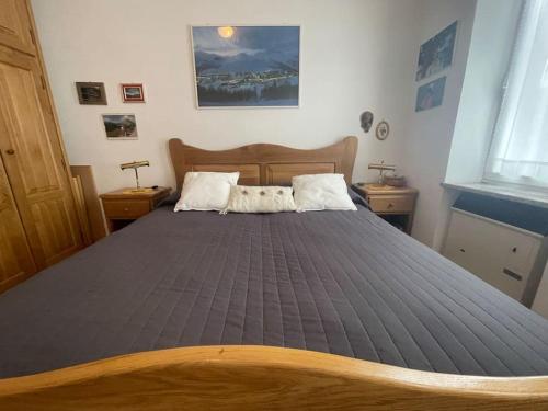 a large bed in a bedroom with two night stands at Bilocale elegante a Pragelato in Pragelato