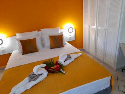 a bedroom with towels and flowers on a bed at Au Nid de KLOE, proche plage privée in Grand-Bourg