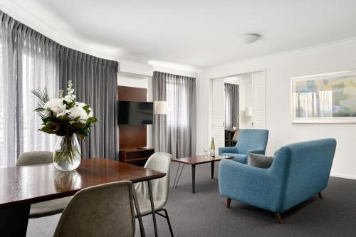 a living room with a vase of flowers on a table at Quest West End in Perth