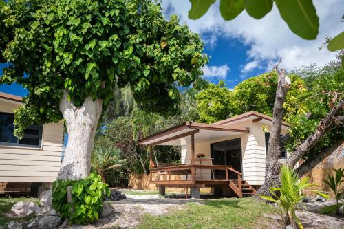 una casa con un árbol delante de ella en Matira Beach Raitea 1, en Bora Bora