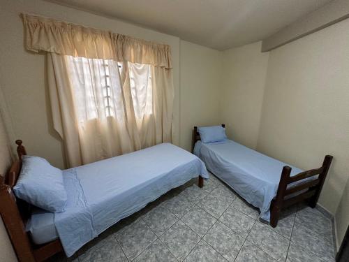 2 łóżka w małym pokoju z oknem w obiekcie 3 Quartos ótimo custo benefício Angra Garatucaia w mieście Angra dos Reis