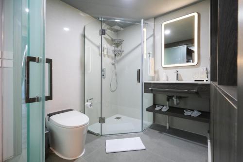 a bathroom with a shower and a toilet and a sink at Aster Apartment Bali in Canggu