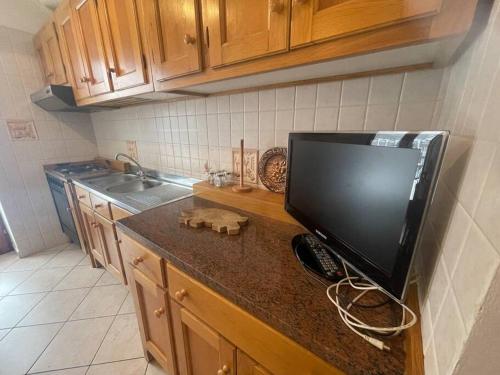 a kitchen with a flat screen tv on a counter at Bilocale a Pragelato in Pragelato