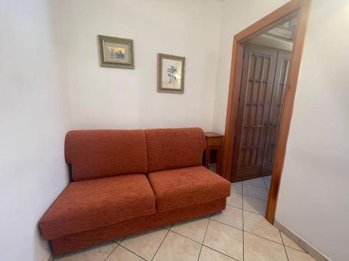 a brown couch sitting in a corner of a room at Bilocale a Pragelato in Pragelato