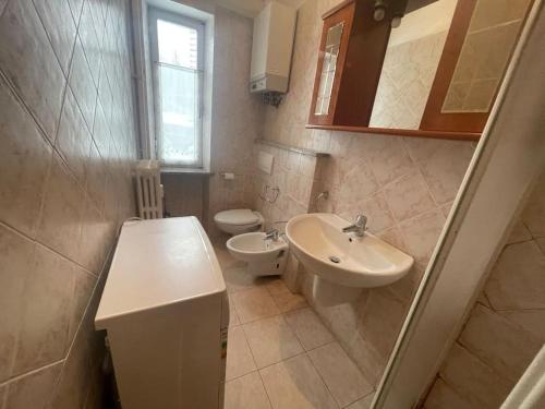 a bathroom with a sink and a toilet at Bilocale a Pragelato in Pragelato