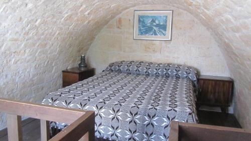 een slaapkamer met een bed in een bakstenen muur bij Trullo Malvisco in Alberobello