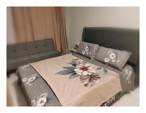 a bed with flowers and a butterfly on it at QC Homestay - Room Only in Pusing