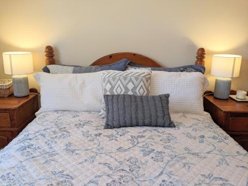 una camera da letto con un letto con cuscini e due lampade di Cottage in Uraidla a Uraidla