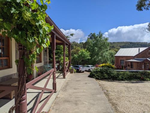 a sidewalk in front of a building with a porch at Cottage in Uraidla in Uraidla