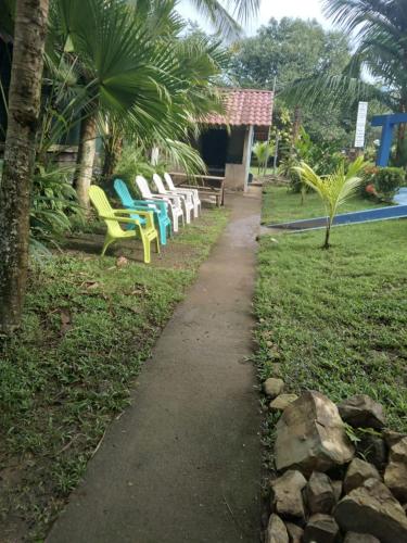 a group of chairs and a path in a park at Villas Maria Luisa in Uvita