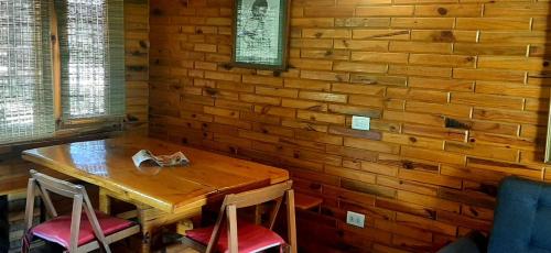una mesa de madera en una habitación con una pared de ladrillo en Cabañas el Recodo de Potrero in 