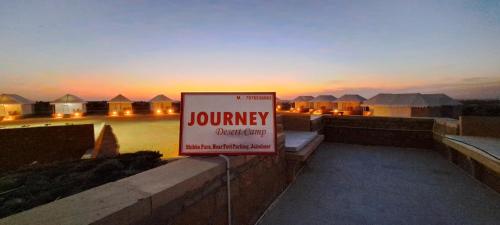 a sign for a luxury desert camp at sunset at Journey Desert Camp Jaisalmer in Jaisalmer