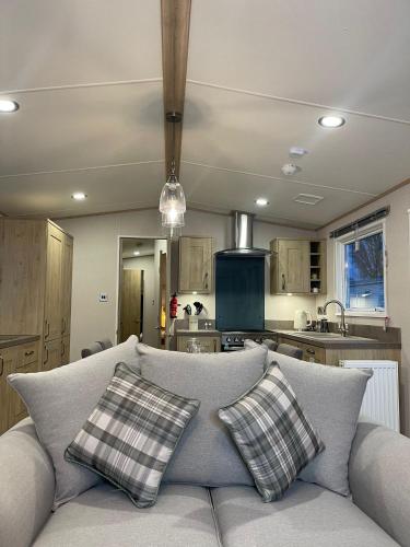 a living room with a couch and a kitchen at 3 BR - Luxury Family Home Near The Beach in East Mersea
