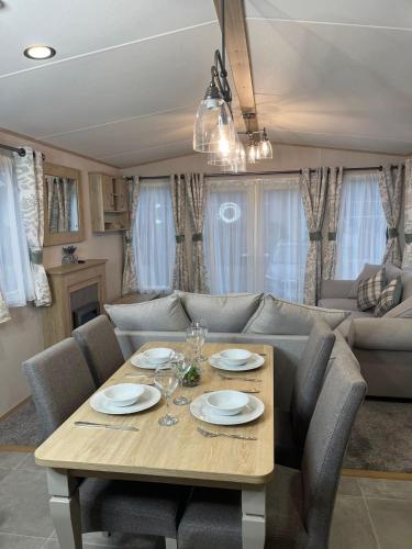 a living room with a table and a couch at 3 BR - Luxury Family Home Near The Beach in East Mersea