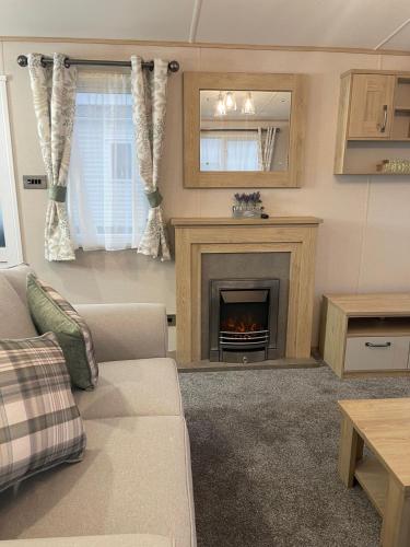 a living room with a couch and a fireplace at 3 BR - Luxury Family Home Near The Beach in East Mersea