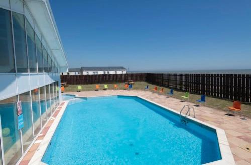 a large swimming pool on the side of a building at 3 BR - Luxury Family Home Near The Beach in East Mersea