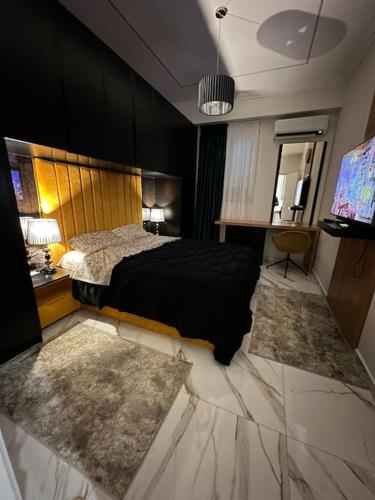 um quarto com uma cama preta e uma televisão em Skyen Luxury Apartments em Durrës