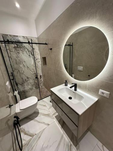 uma casa de banho com um lavatório e um espelho em Skyen Luxury Apartments em Durrës