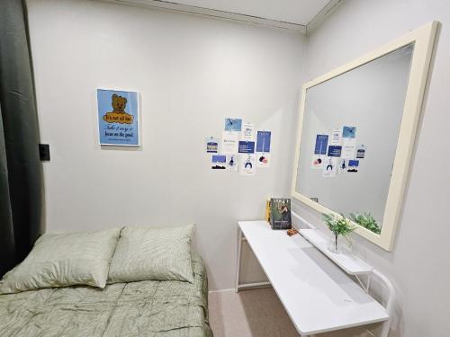 1 dormitorio con cama, mesa y espejo en Seoul Stay, en Seúl
