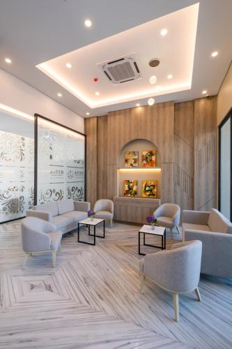 a waiting room with couches and tables at Aster Apartment Bali in Canggu