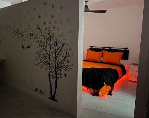 a bedroom with a tree stenciled on the wall at Magnolias Suite in Lehigh Acres